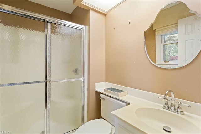 bathroom with vanity, toilet, and a shower with door