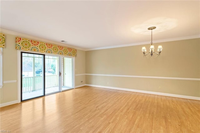 unfurnished room featuring crown molding, hardwood / wood-style floors, and a notable chandelier