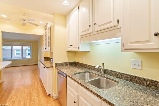 kitchen with white cabinetry, sink, dishwasher, dark stone counters, and light wood-type flooring