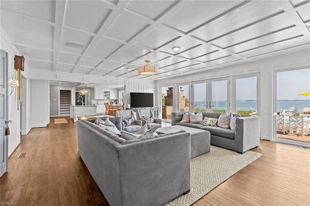 living room featuring hardwood / wood-style floors, french doors, sink, and coffered ceiling