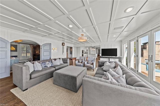 living room featuring wood-type flooring, french doors, a wealth of natural light, and coffered ceiling