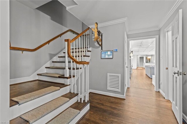 stairs featuring crown molding and hardwood / wood-style floors