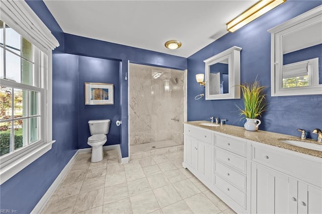 bathroom featuring vanity, toilet, and tiled shower