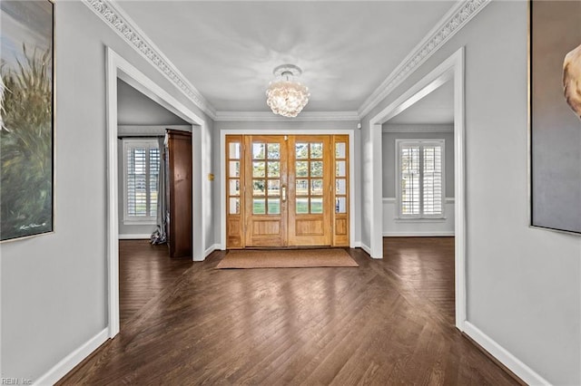 entrance foyer with crown molding, dark wood-type flooring, and an inviting chandelier