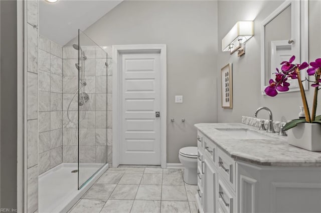 bathroom featuring tiled shower, vanity, toilet, and lofted ceiling