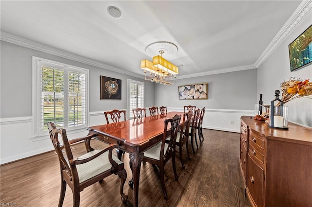 dining room featuring crown molding, dark wood-type flooring, and a chandelier