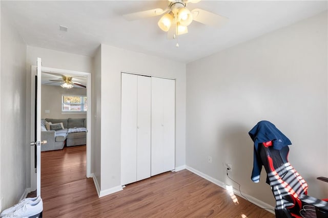 unfurnished bedroom with hardwood / wood-style flooring, ceiling fan, and a closet