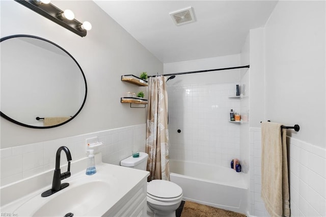 full bathroom with shower / tub combo, vanity, toilet, and tile walls