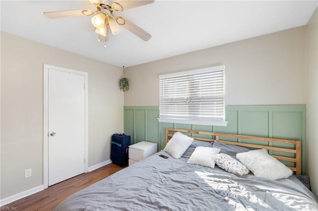 bedroom with dark hardwood / wood-style floors and ceiling fan