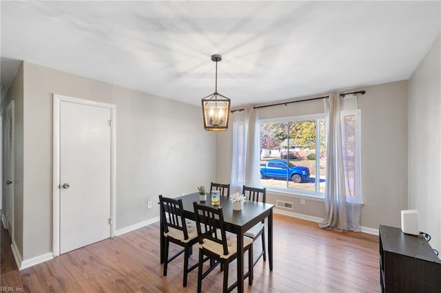 dining area featuring light hardwood / wood-style flooring and a chandelier