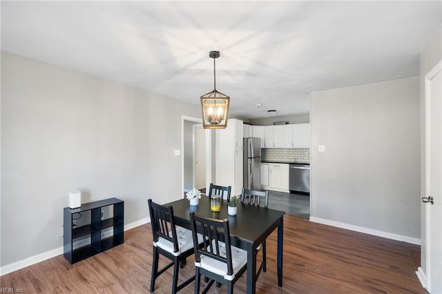 dining space with wood-type flooring and an inviting chandelier