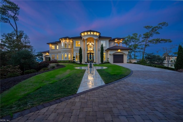 mediterranean / spanish-style house with a lawn and a garage