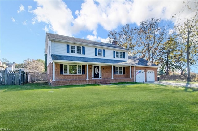 view of front of home featuring covered porch, a garage, and a front lawn