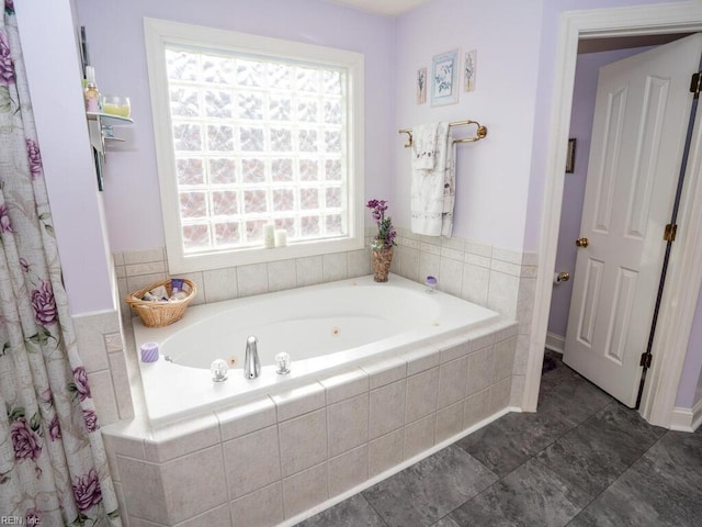 bathroom with tiled tub and plenty of natural light