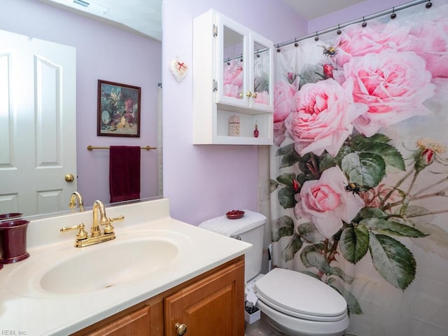 bathroom featuring vanity, toilet, and walk in shower