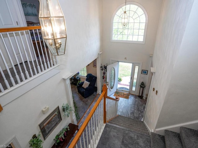 foyer entrance with a notable chandelier and a towering ceiling