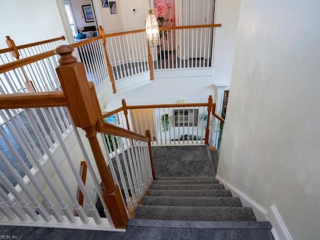 staircase with a chandelier