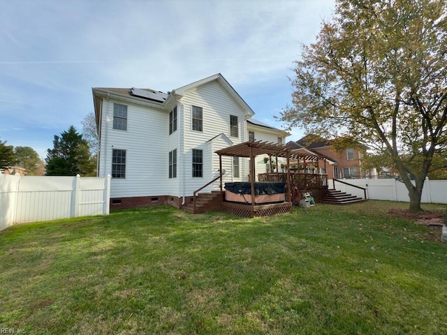 back of house with solar panels, a pergola, a yard, and a wooden deck