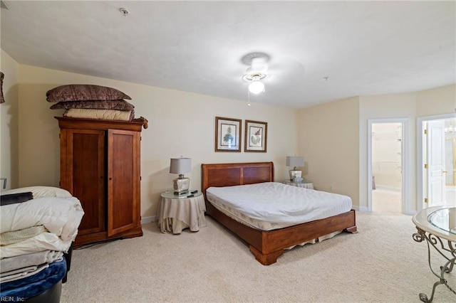 carpeted bedroom with ensuite bathroom and ceiling fan