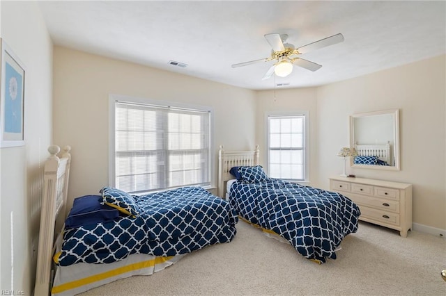 carpeted bedroom featuring multiple windows and ceiling fan