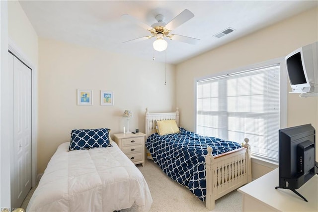 bedroom featuring light carpet, a closet, and ceiling fan