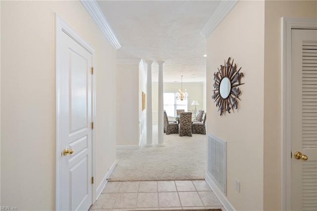 hallway featuring light carpet, an inviting chandelier, ornate columns, and crown molding