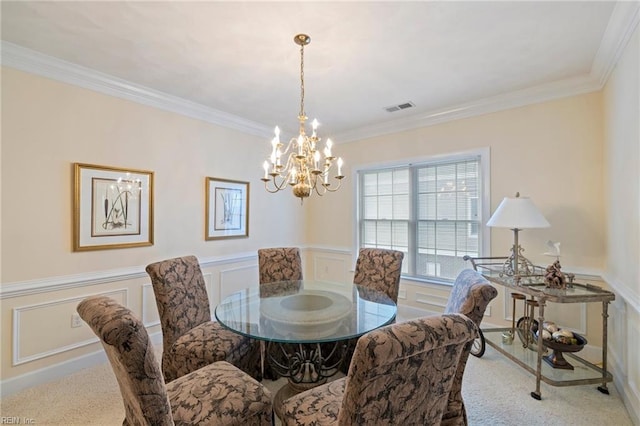 carpeted dining room featuring a chandelier and ornamental molding