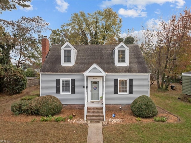 cape cod home featuring a front yard