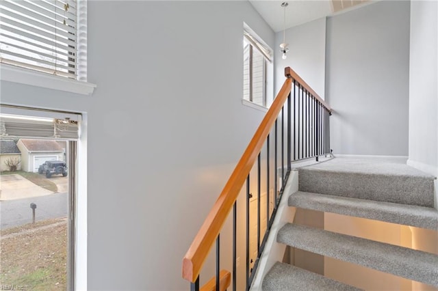 staircase with carpet floors and a healthy amount of sunlight