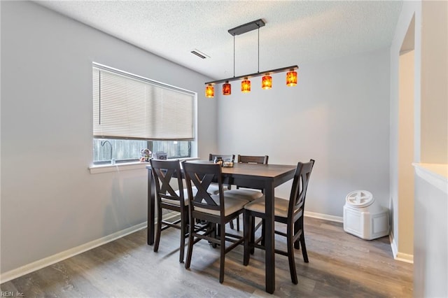 dining area featuring a textured ceiling and dark hardwood / wood-style floors