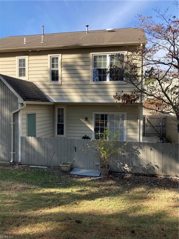 rear view of property featuring a yard