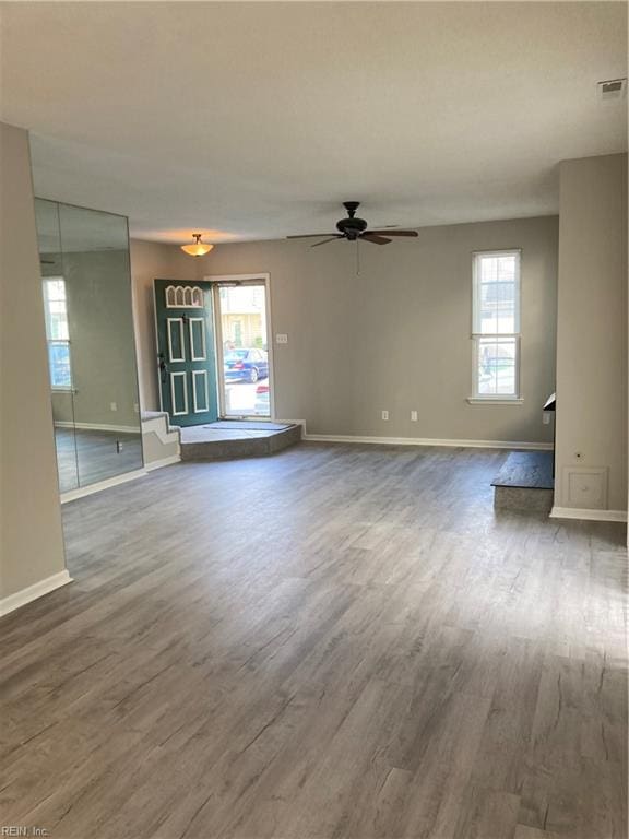 unfurnished living room with ceiling fan and wood-type flooring