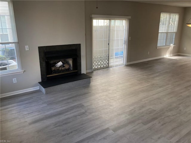 unfurnished living room with wood-type flooring and a wealth of natural light