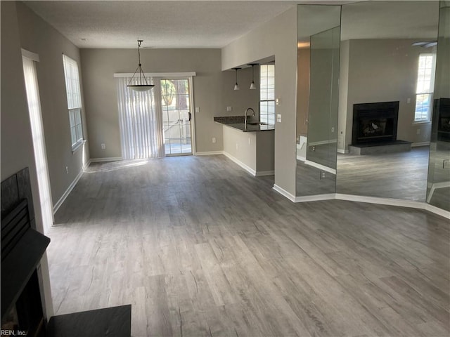 unfurnished living room with hardwood / wood-style floors, a textured ceiling, and sink