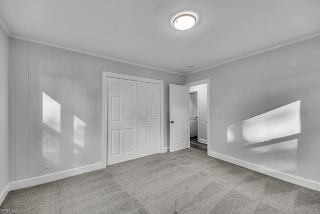 unfurnished bedroom featuring carpet floors, crown molding, and a closet