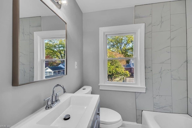 bathroom with vanity, toilet, and a wealth of natural light