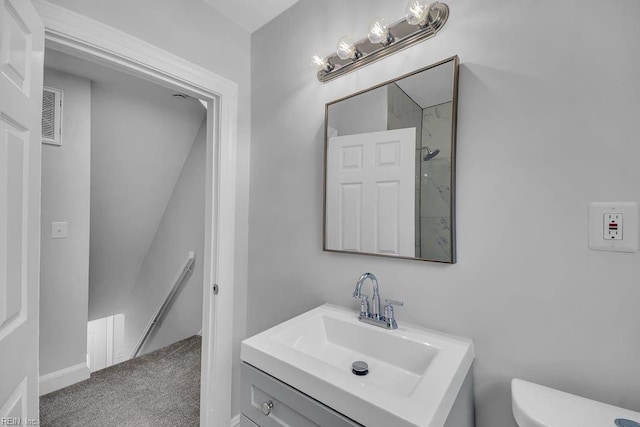 bathroom with a shower, vanity, and toilet