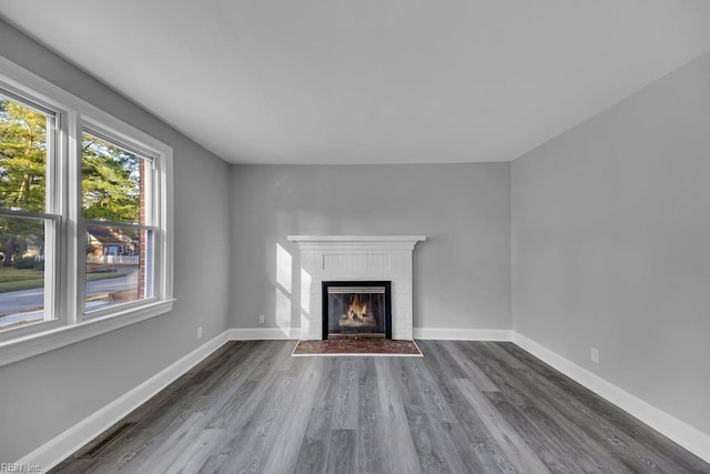 unfurnished living room with a fireplace and dark wood-type flooring