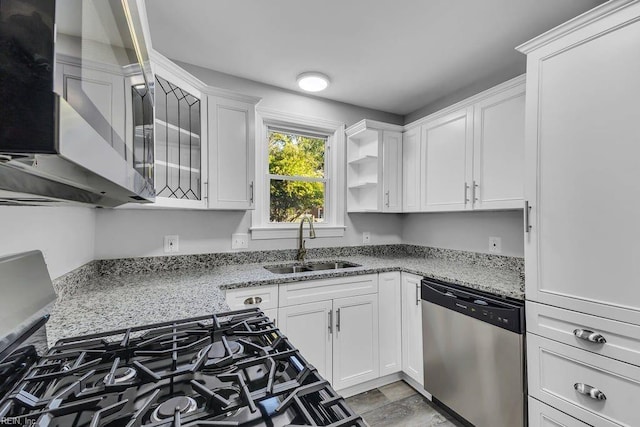 kitchen featuring white cabinets, light stone counters, sink, and appliances with stainless steel finishes