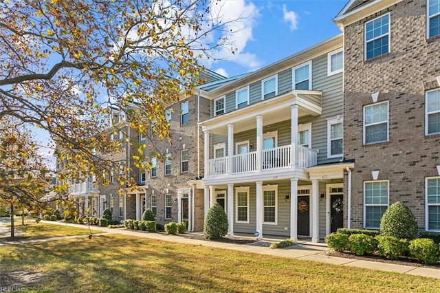 view of front of property featuring a balcony and a front yard