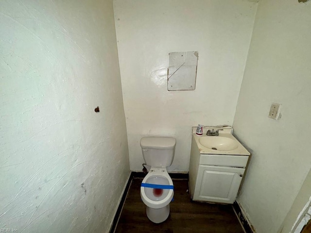 bathroom with toilet, vanity, and hardwood / wood-style flooring