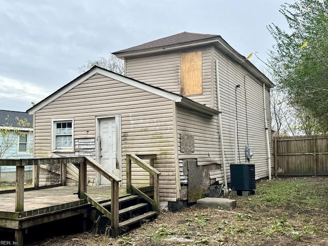 rear view of property featuring a wooden deck and cooling unit