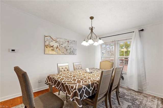 129 Arapahoe Trl, Hertford, NC 27944 - dining room with a chandelier, wood finished floors, baseboards, and a textured ceiling