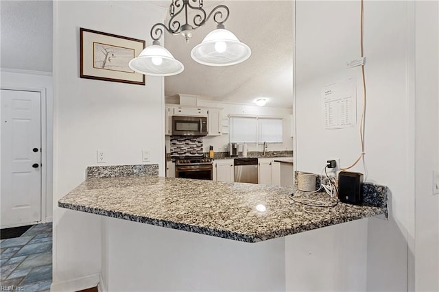 kitchen with kitchen peninsula, decorative backsplash, decorative light fixtures, white cabinetry, and stainless steel appliances