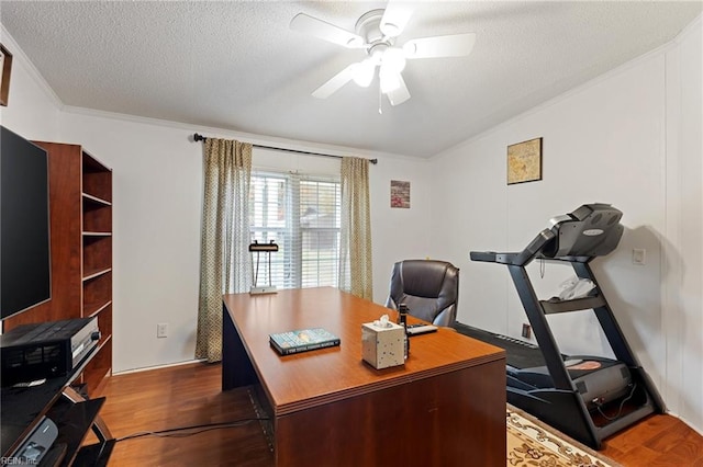 office space featuring dark hardwood / wood-style floors, ceiling fan, crown molding, and a textured ceiling