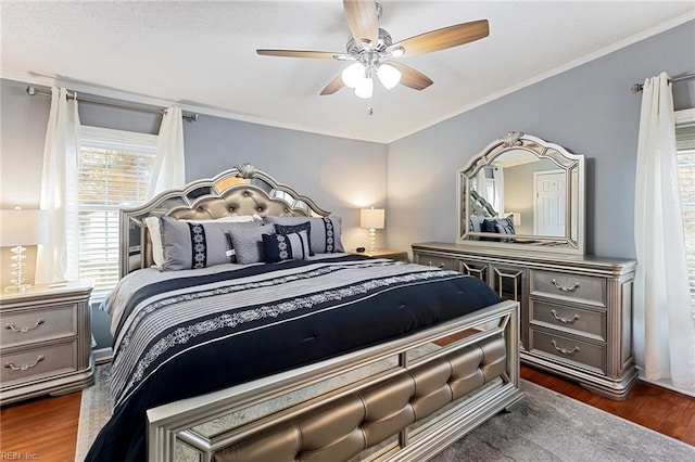 bedroom with ornamental molding, ceiling fan, and dark wood-type flooring