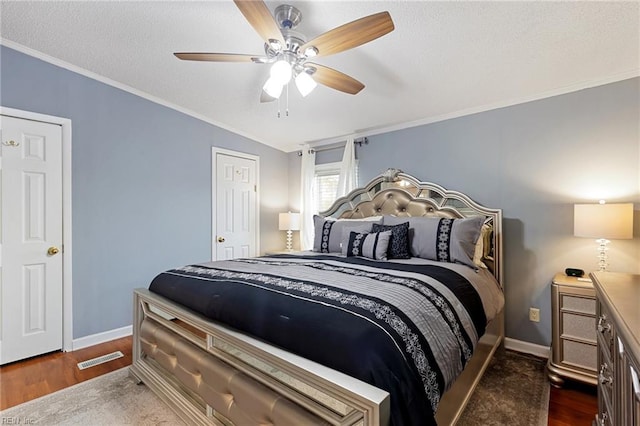 bedroom with ceiling fan, crown molding, dark wood-type flooring, and a textured ceiling