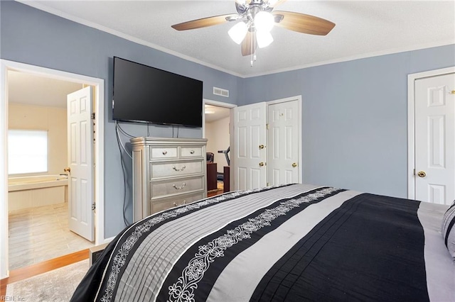 bedroom featuring connected bathroom, ceiling fan, light hardwood / wood-style flooring, and crown molding