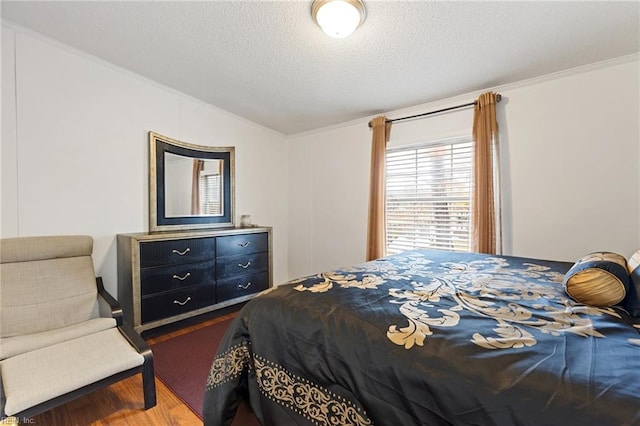 bedroom with hardwood / wood-style floors, a textured ceiling, and crown molding