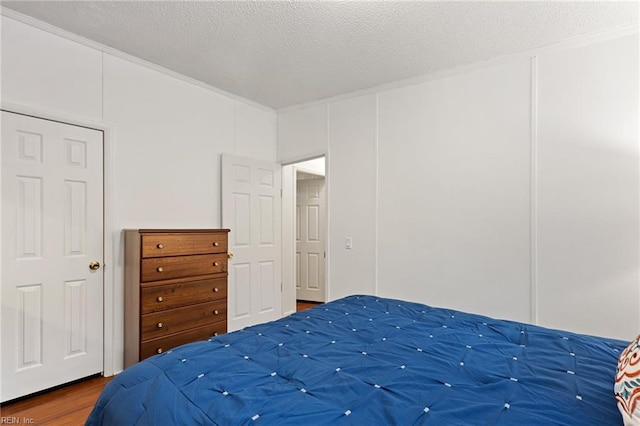 bedroom featuring wood-type flooring and a textured ceiling